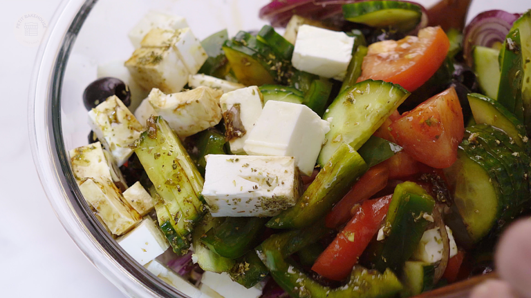 freshly tossed greek salad in a salad bowl
