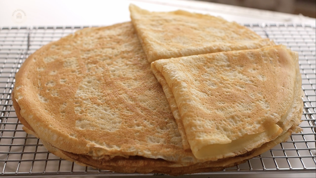 Stack of thin, golden French crêpes folded