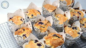 Warm Jordan Marsh blueberry muffins just out of the oven, golden and cracked on top.