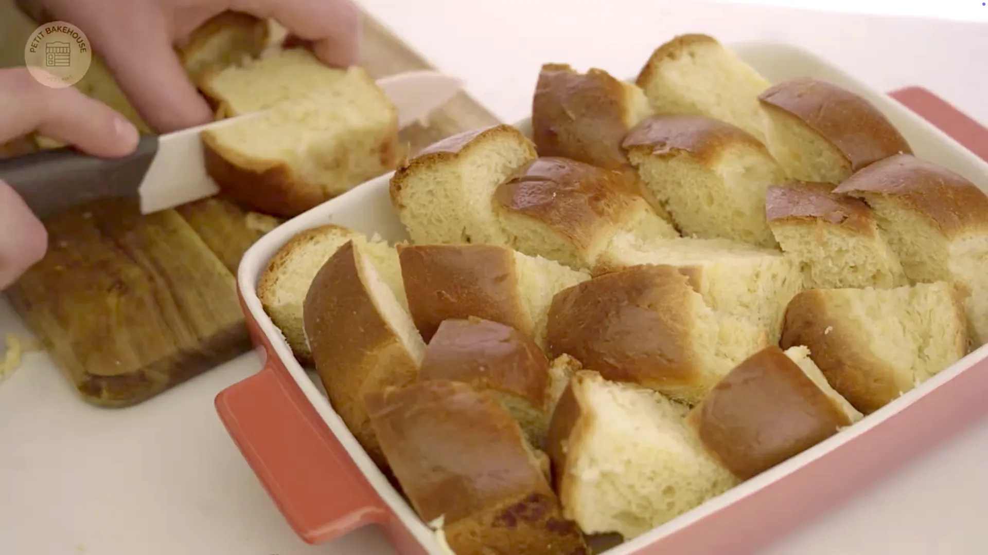 Large cubes of brioche or challah neatly filling the buttered baking dish