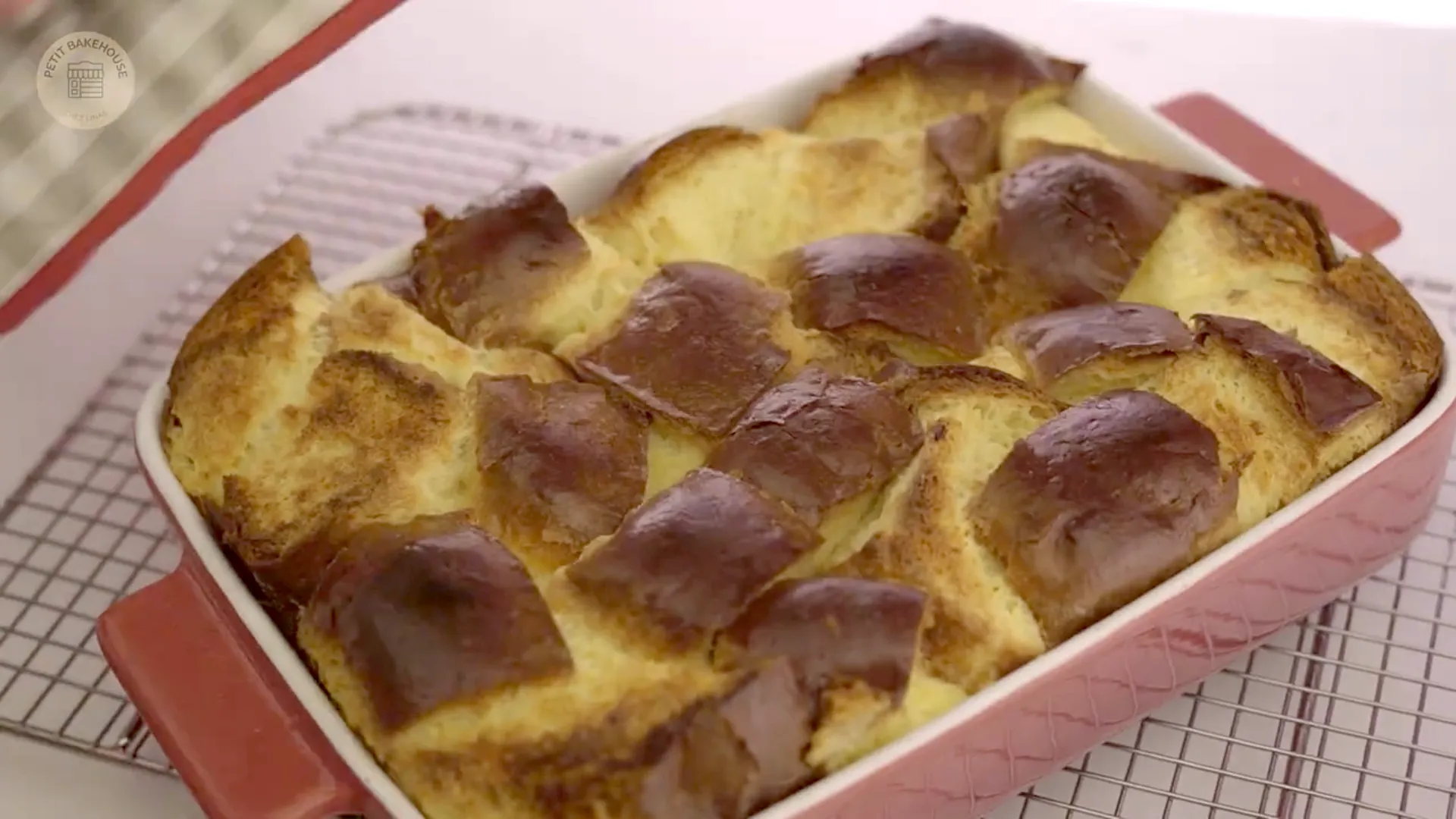 Golden-baked bread pudding just out of the oven in a red baking dish