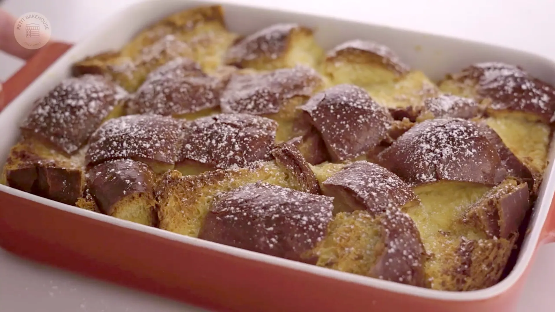 Overhead view of bread pudding in a red baking dish